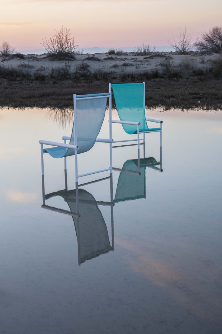 Deux chaises bleues en Batyline Color posées sur l’eau au lever du soleil