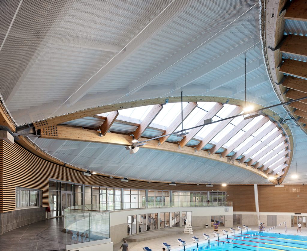 Indoor Olympic swimming pool at Aquatic Center of Taverny with curved laminated timber roof structure