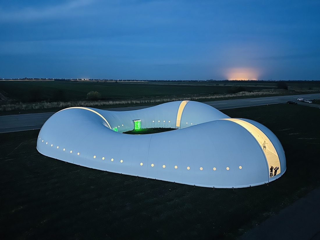 Structure textile éclairée au crépuscule avec lumière intérieure visible.