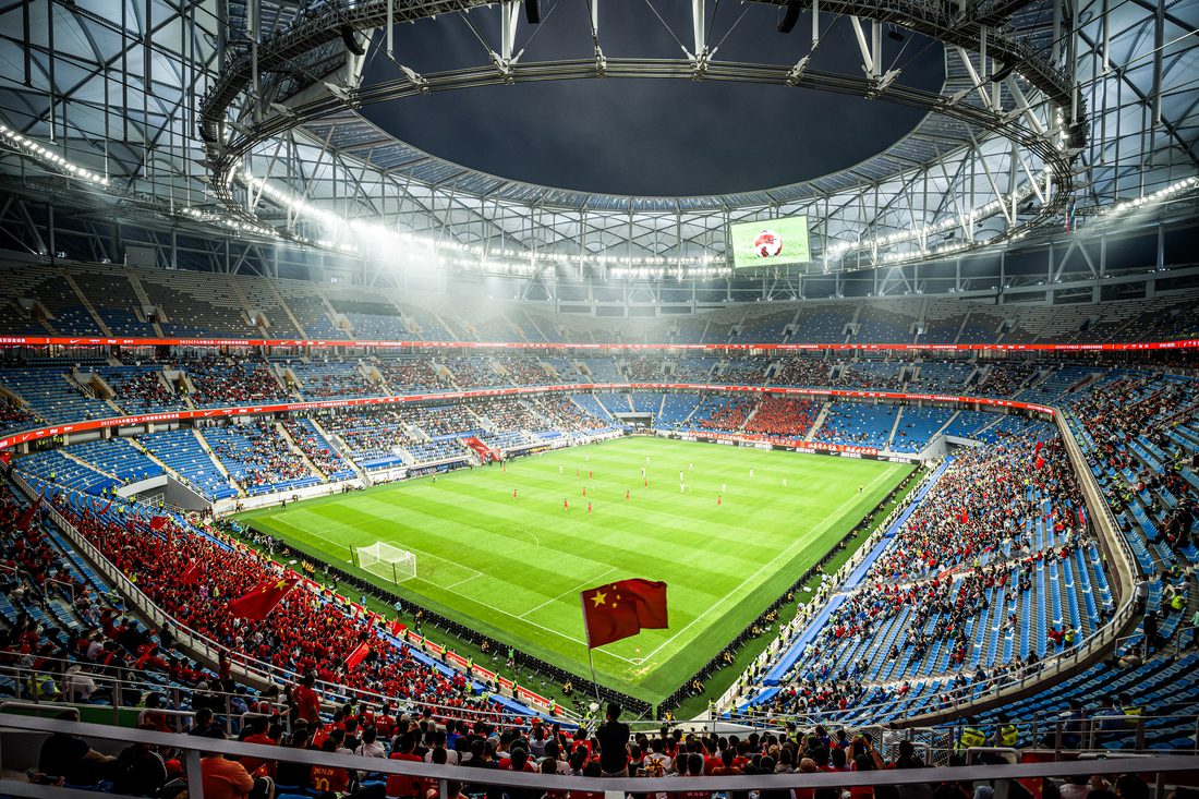 Intérieur du stade de Dalian avec toiture textile PTFE et structure métallique apparente.