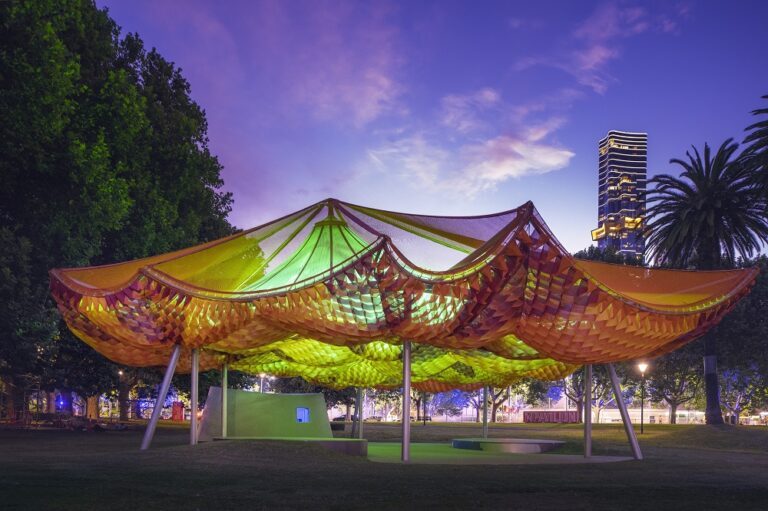 MPavilion Melbourne illuminé la nuit avec membrane textile Serge Ferrari et structure architecturale ondulante