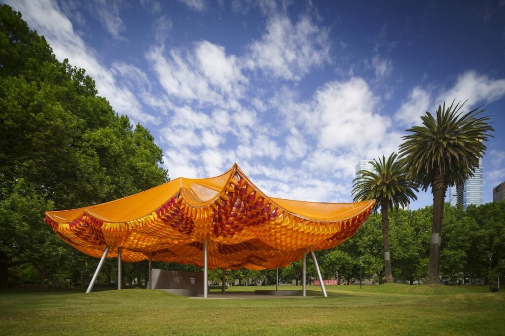 MPavilion Melbourne structure textile orange Serge Ferrari dans un parc urbain
