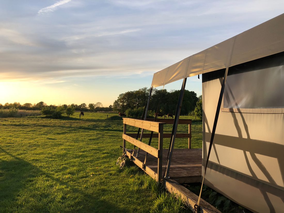Habitat léger en plein air avec toile technique en membrane composite souple Serge Ferrari, offrant protection et confort dans un environnement naturel.