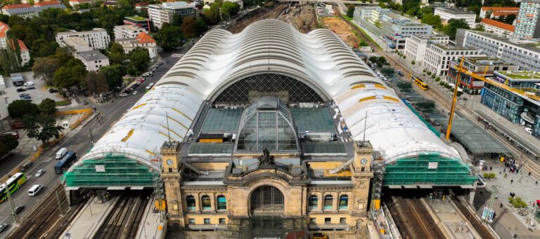 Vue aérienne de la gare centrale avec toiture textile ondulée en cours de rénovation et intégration urbaine.
