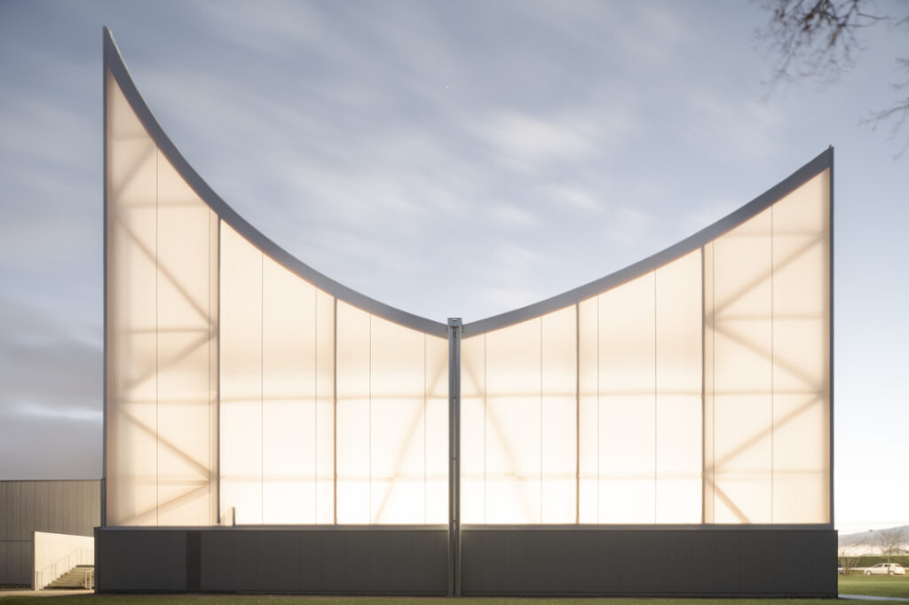 Façade d’un bâtiment sportif avec membrane textile translucide rétroéclairée, utilisant la toile Tenseo 902 S2.