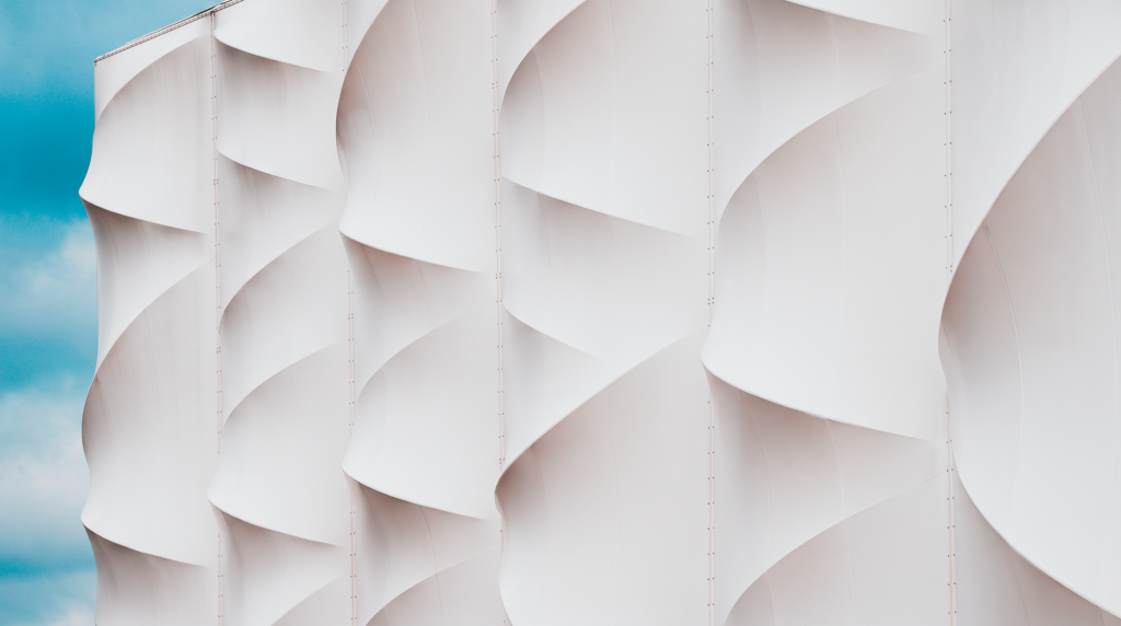 Façade textile ondulée composée de membranes architecturales aux formes courbes.