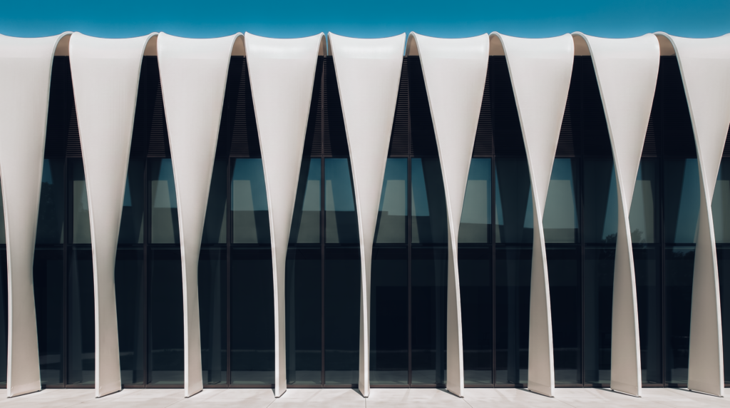 Façade contemporaine composée de membranes textiles verticales créant une enveloppe architecturale légère.