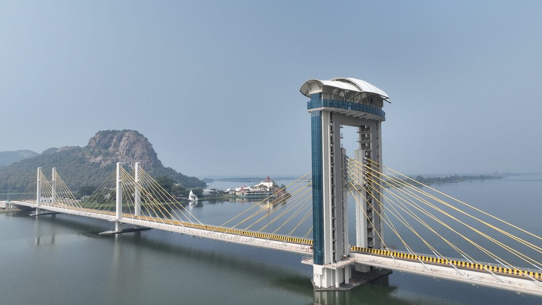 Ambhora Bridge de jour traversant un plan d’eau avec collines en arrière-plan.