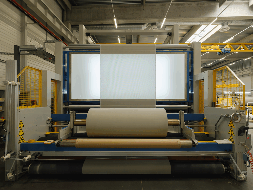 Contrôle qualité d’une membrane composite Serge Ferrari dans l’atelier — vérification visuelle du matériau