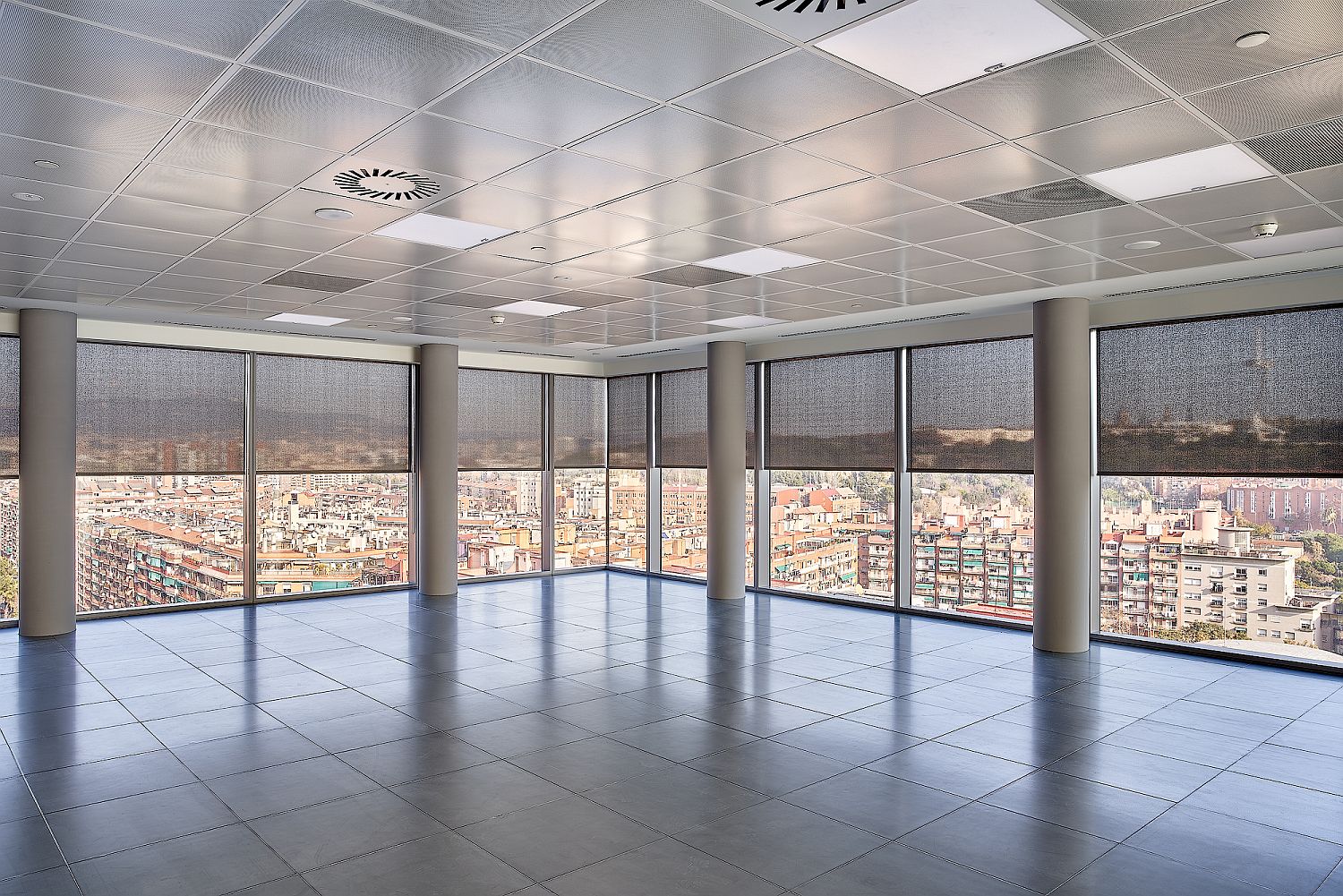Intérieur de bureaux Porta Firal avec stores techniques filtrant la lumière naturelle