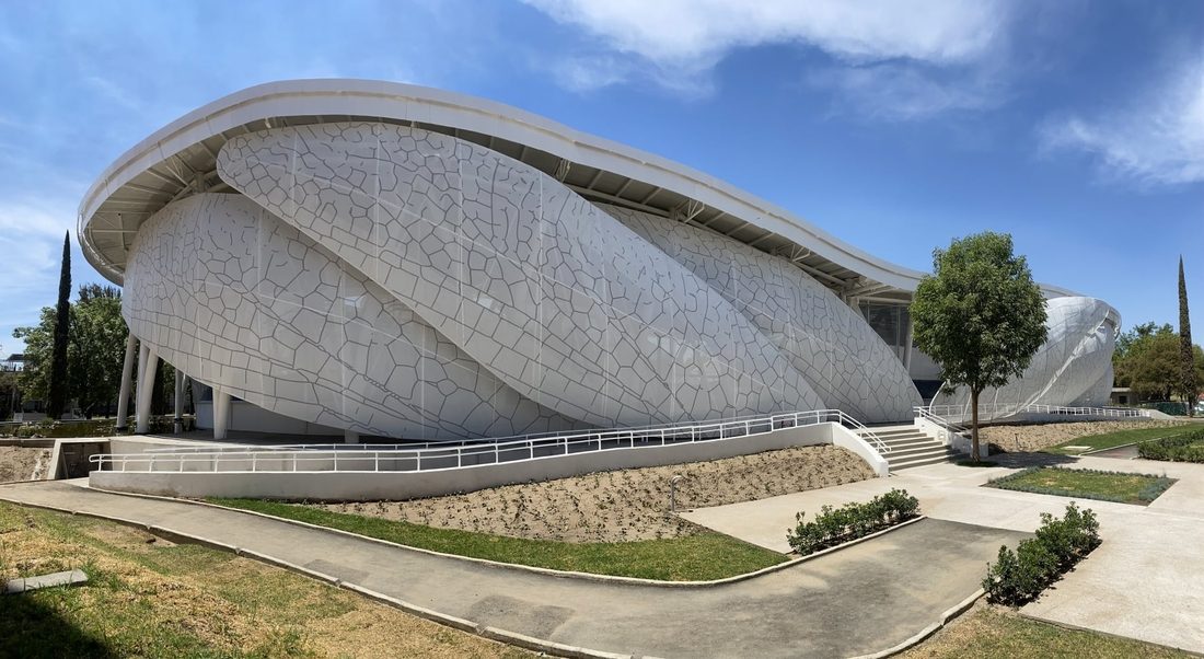 Global exterior view of the Dragonfly Museum façade featuring custom-printed Tenseo Frontside 381 wing-like panels and surrounding pathways.