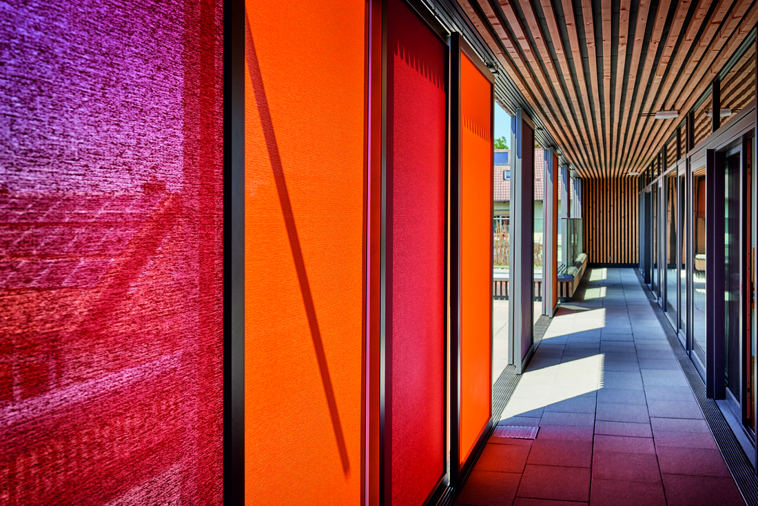 Circulation extérieure d’une crèche protégée par des toiles Soltis 92 colorées