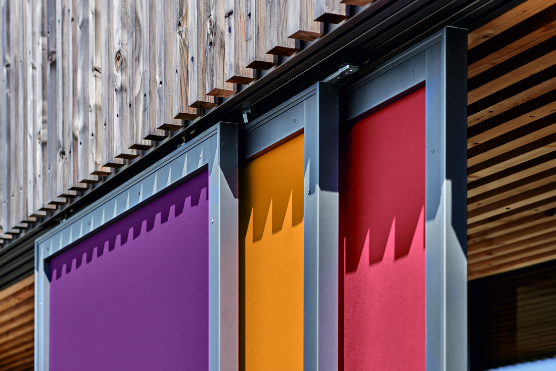 Détail de fixation de protection solaire textile Soltis 92 sur façade bois