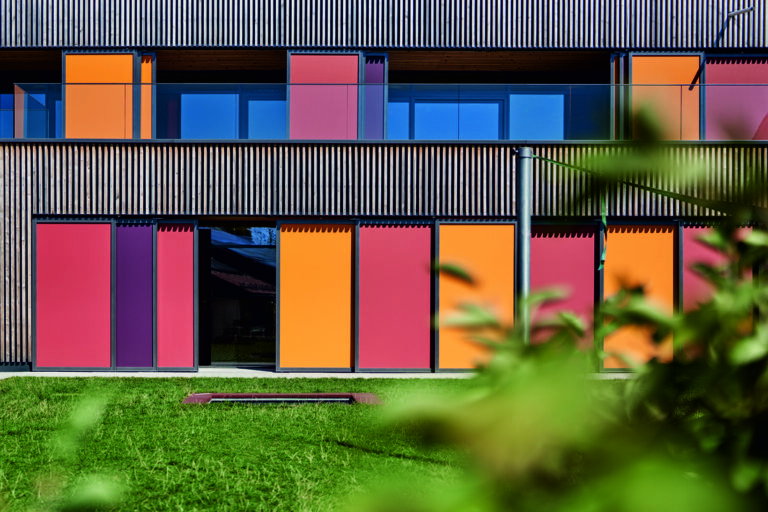 Façade d’une crèche contemporaine équipée de protections solaires colorées Soltis 92 de Serge Ferrari