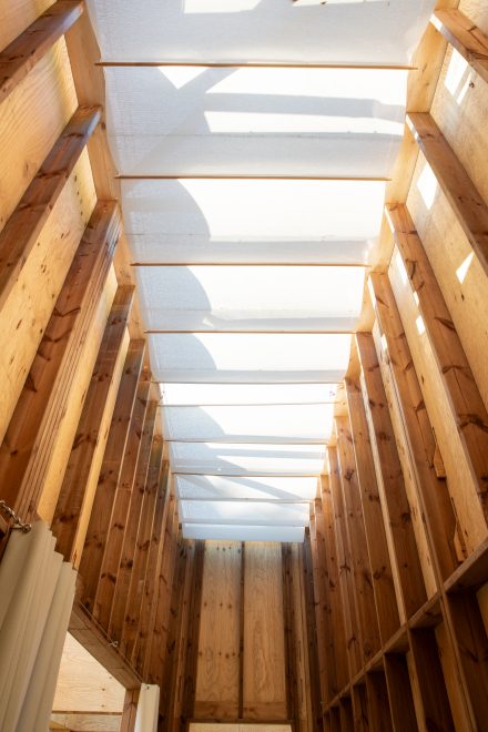 Vue intérieure de la structure du Forum des Vestiges avec toiture textile diffusant la lumière naturelle