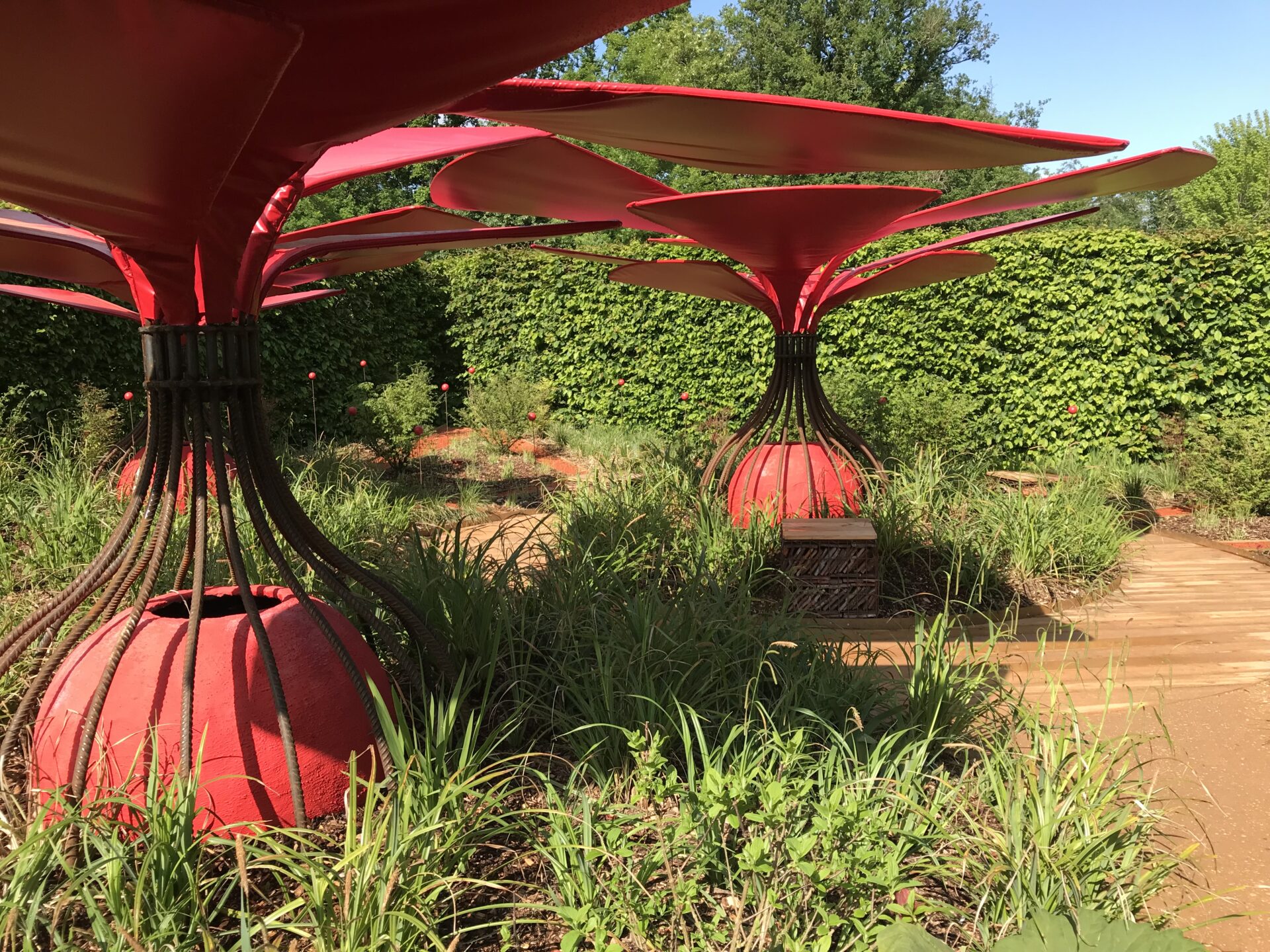 Structures d’ombrage rouges en forme de fleurs dans un jardin