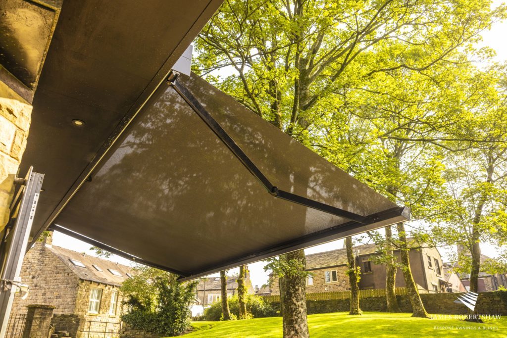 Store banne en membrane composite souple Soltis Serge Ferrari pour protection solaire sur terrasse de restaurant