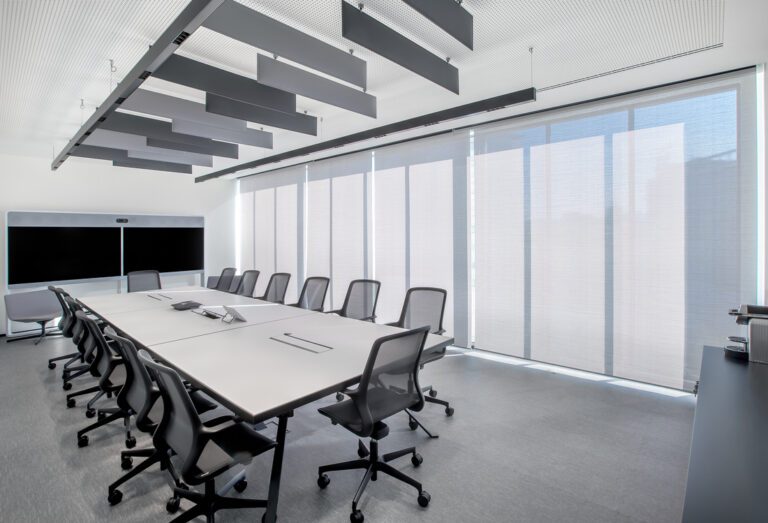 Grande salle de réunion équipée de stores enrouleurs Soltis Touch Bridge 3 pour un confort optimal.