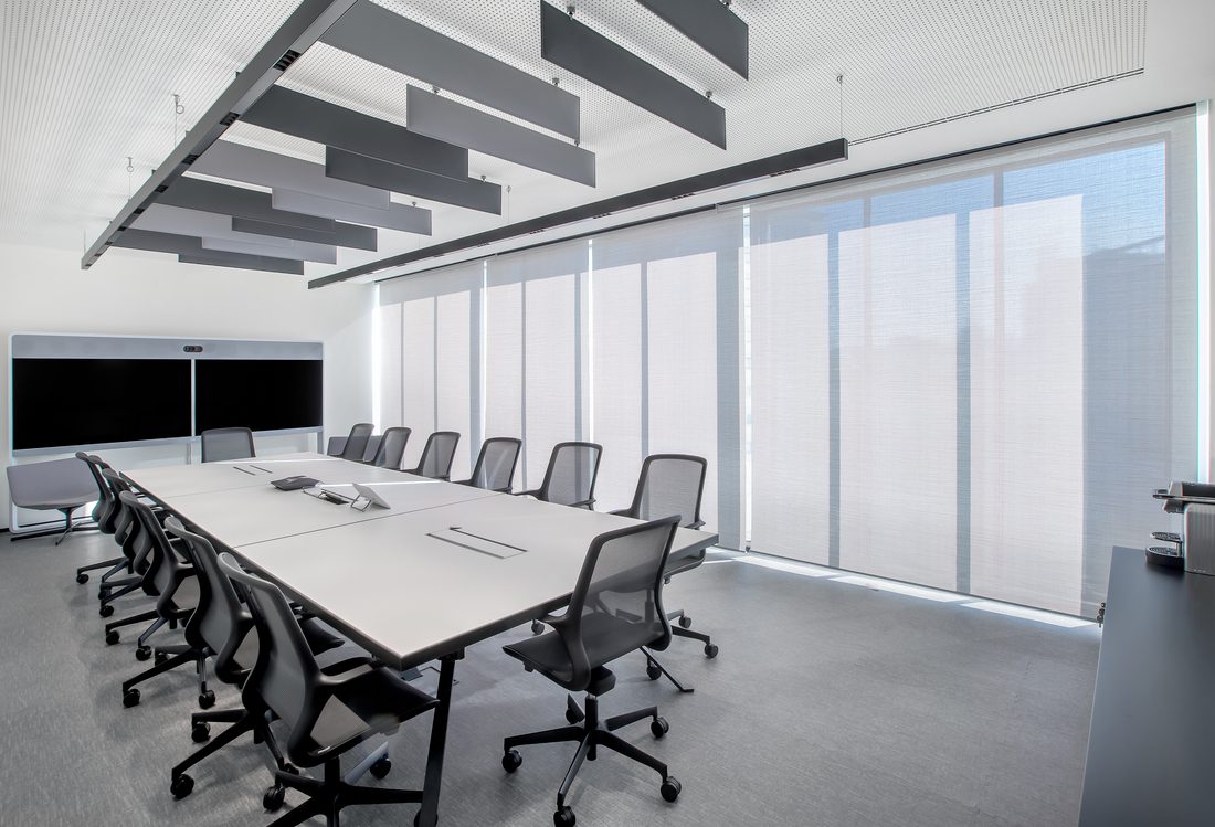 Grande salle de réunion équipée de stores enrouleurs Soltis Touch Bridge 3 pour un confort optimal.