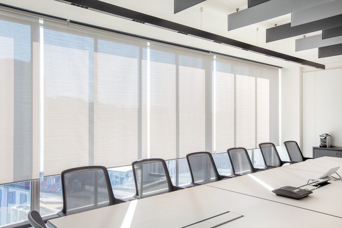Salle de réunion équipée de stores intérieurs en membranes composites souples Serge Ferrari pour contrôle solaire et confort visuel