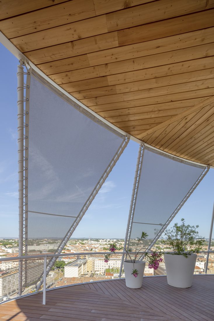 Toile technique tendue sur rooftop offrant protection solaire et vue panoramique