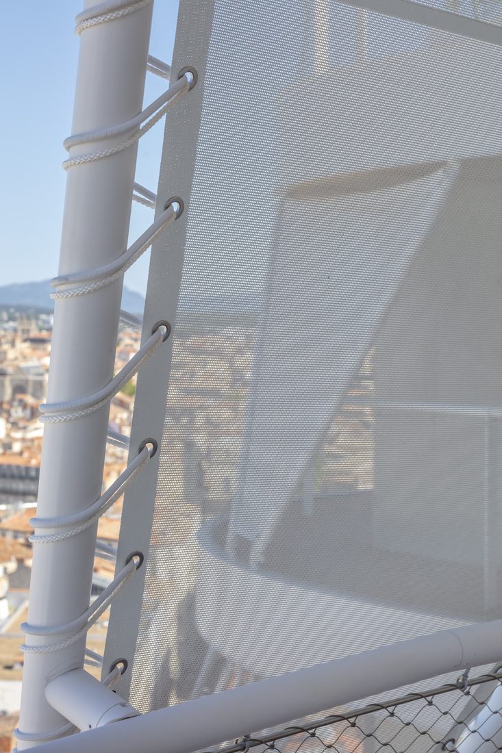 Toile technique micro-perforée fixée par laçage sur structure rooftop