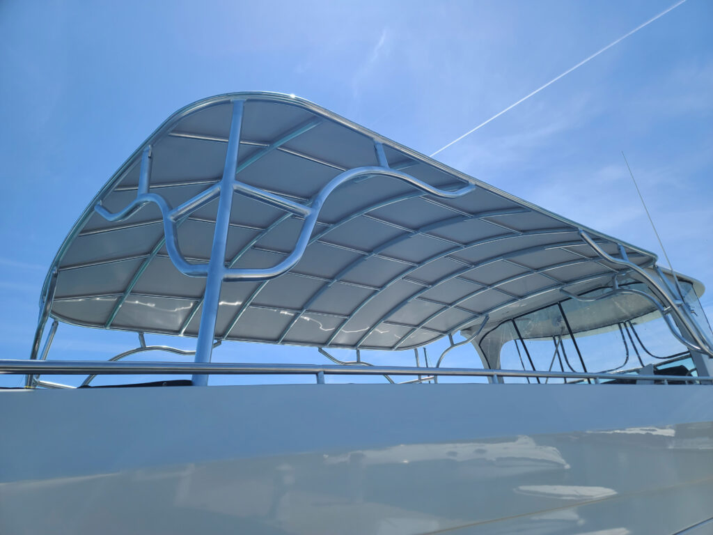 Close-up of the Stamoid Top fabric panels and tubular frame forming the permanent top canopy on a Bluewater Coastal Cruiser 68.