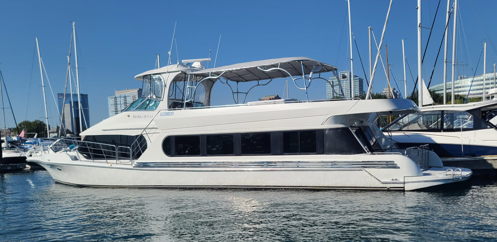 Side profile of a Bluewater Coastal Cruiser 68 at the marina with the Stamoid Top permanent upper-deck canopy installed.