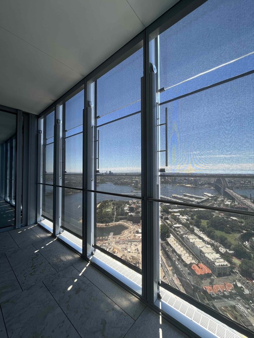 Vue intérieure d’un bâtiment équipé de stores en toile technique Serge Ferrari filtrant la lumière tout en préservant la vue panoramique.
