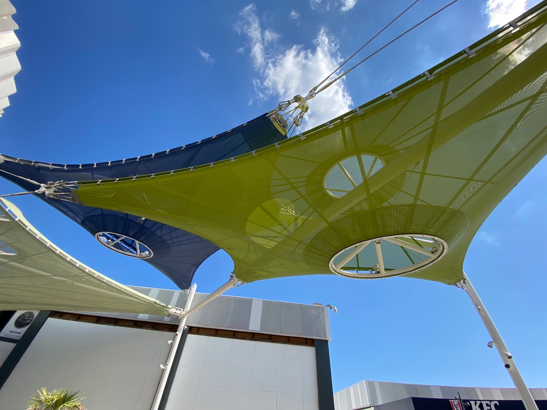 Voiles d'ombrage textiles bleues et vertes installées au-dessus des allées du centre commercial de Porto Pi à Majorque.
