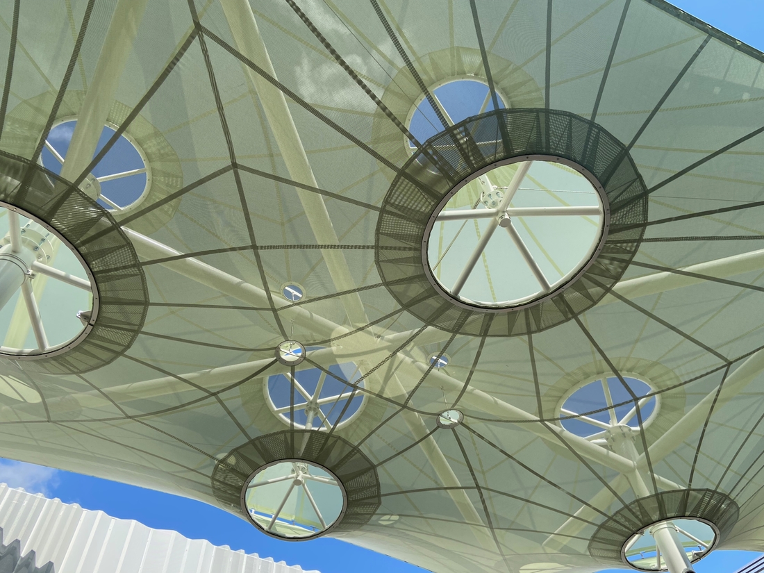 Détail des anneaux et de la structure métallique d'une voile d'ombrage.