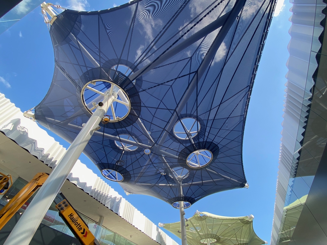 Deux voiles d'ombrage textiles aux couleurs contrastées vues depuis le dessous.