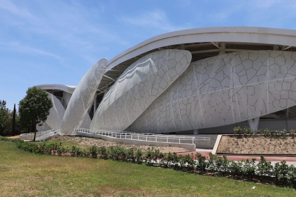 Wide daytime view of the Dragonfly Museum showing multiple wing-shaped façade panels made with custom-printed Tenseo Frontside 381.