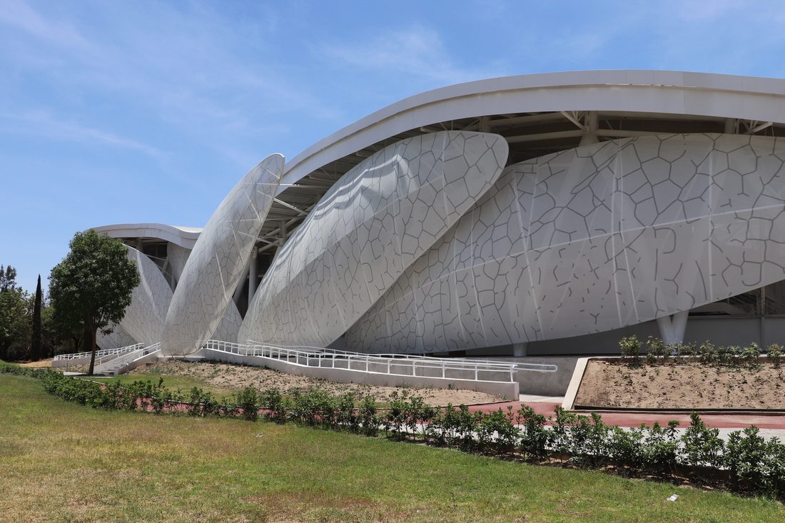 Wide daytime view of the Dragonfly Museum showing multiple wing-shaped façade panels made with custom-printed Tenseo Frontside 381.
