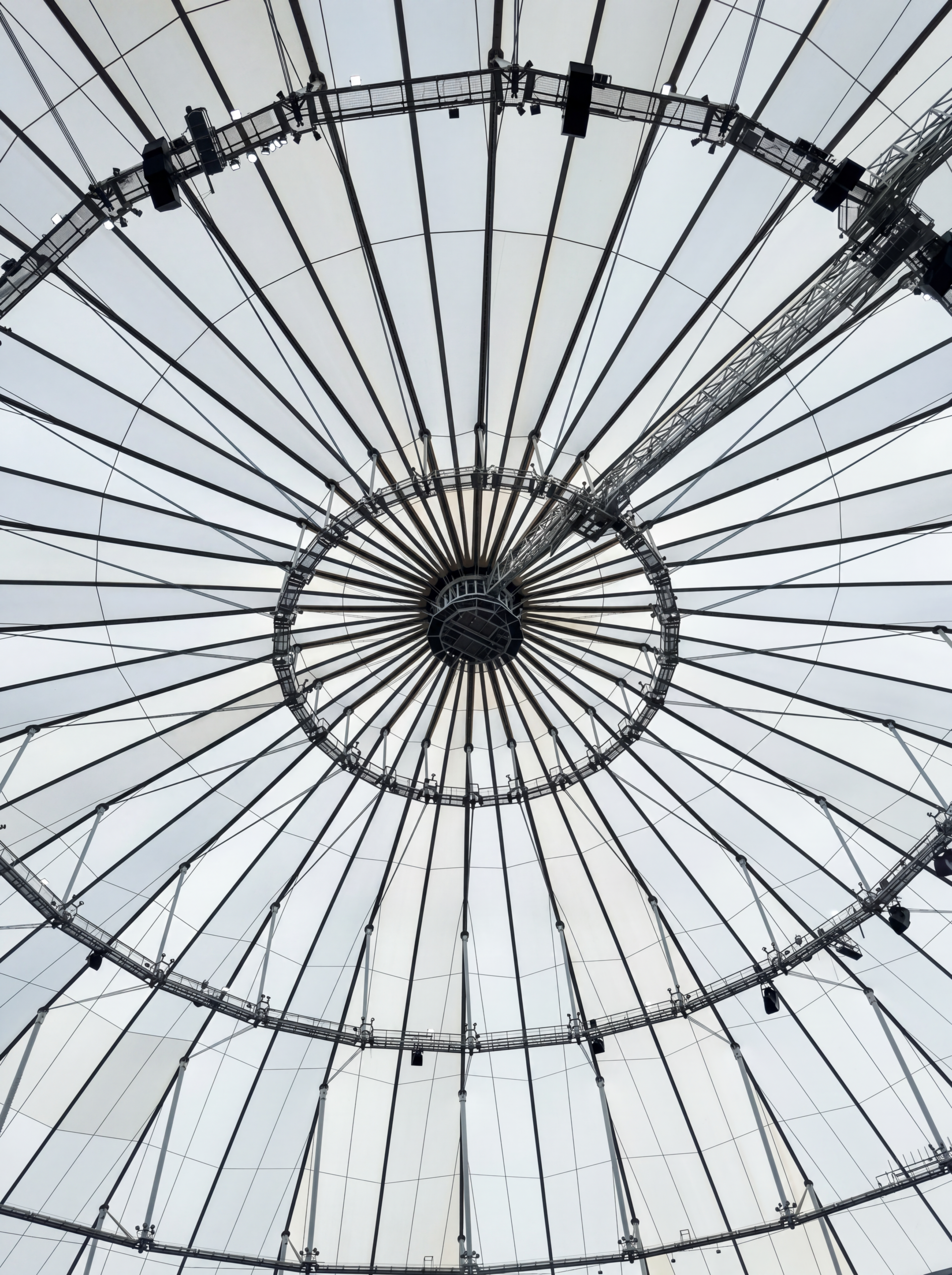 Upward view of the central compression ring and radial cable network supporting a tensile membrane roof.