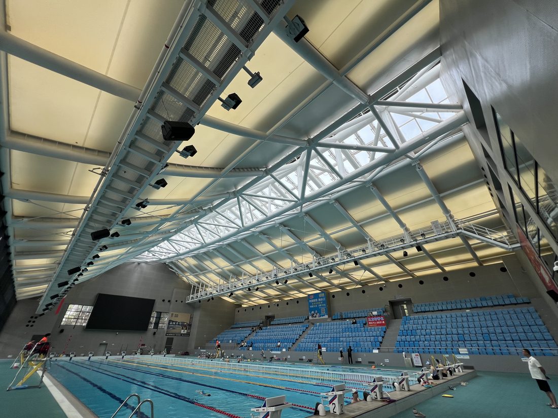 Plafond en membrane acoustique Serge Ferrari dans un centre aquatique, optimisant l’absorption sonore et la lumière naturelle.