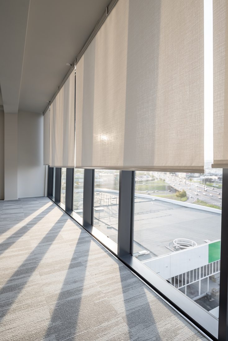 Stores intérieurs en toile technique filtrant la lumière dans un bureau