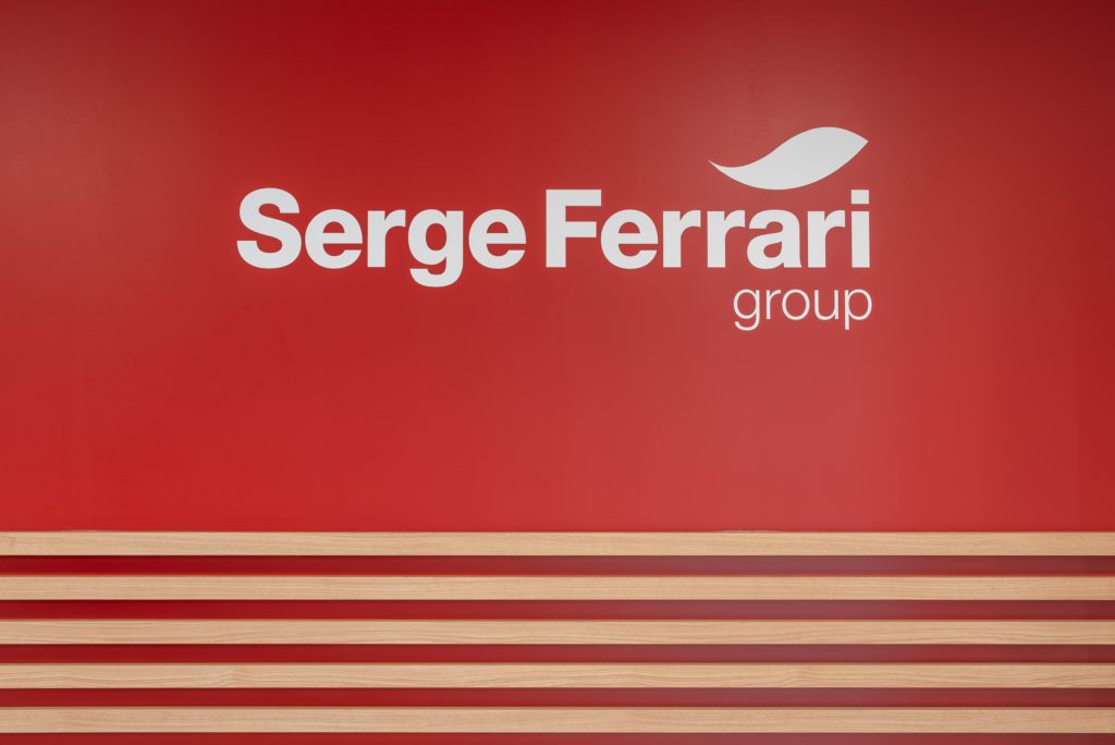 Logo du Groupe Serge Ferrari apposé sur un mur intérieur du bâtiment