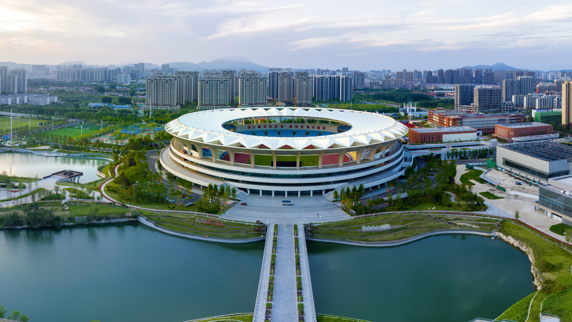 Aerial view of Kuishan Stadium with PTFE roof overlooking landscaped water features