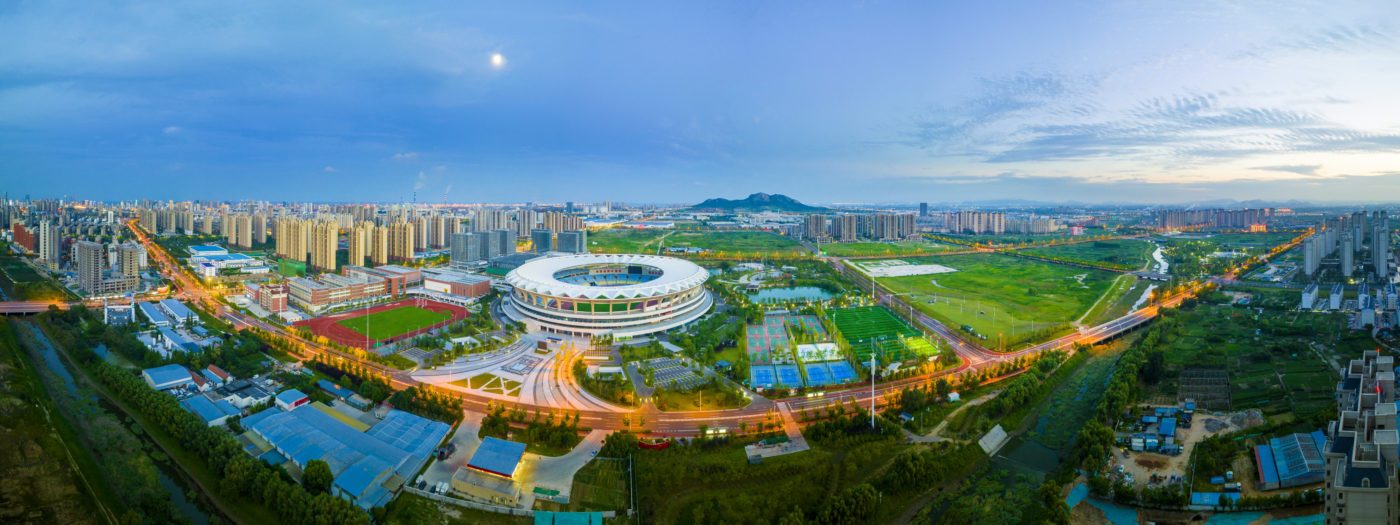 Panoramic aerial view of Kuishan Stadium and surrounding urban landscape at dusk in Rizhao