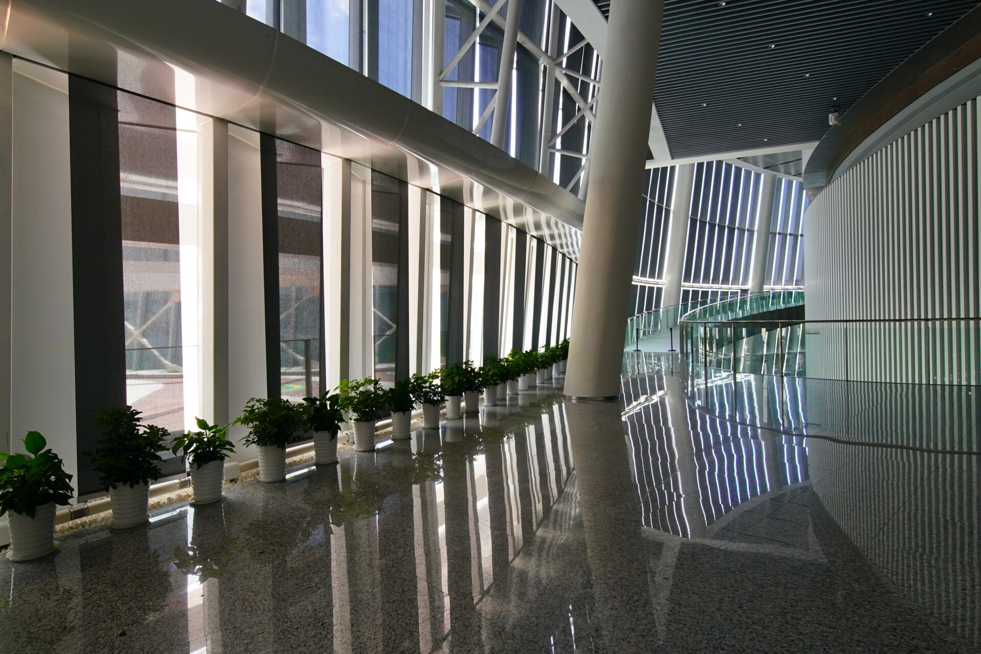 Interior façade with vertical solar screens, structural columns and indoor greenery