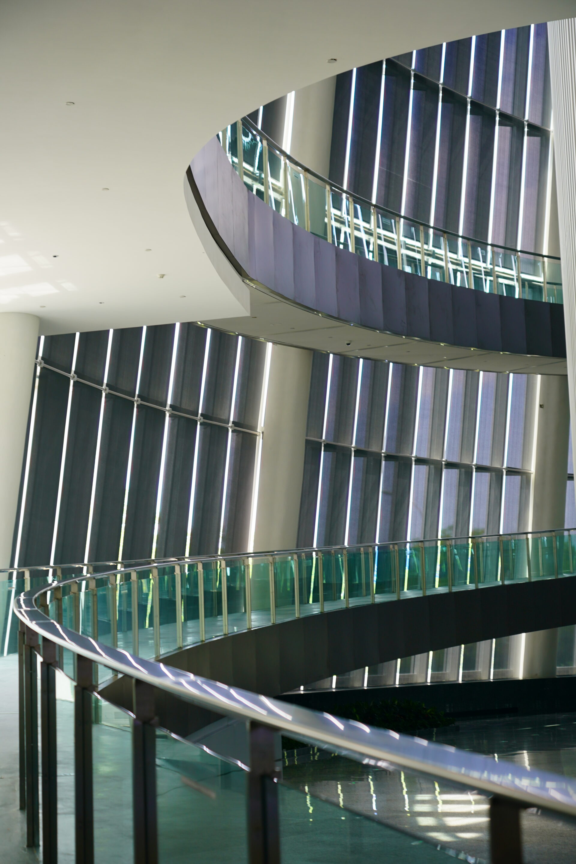 Curved interior walkway with textile solar screens and natural light control