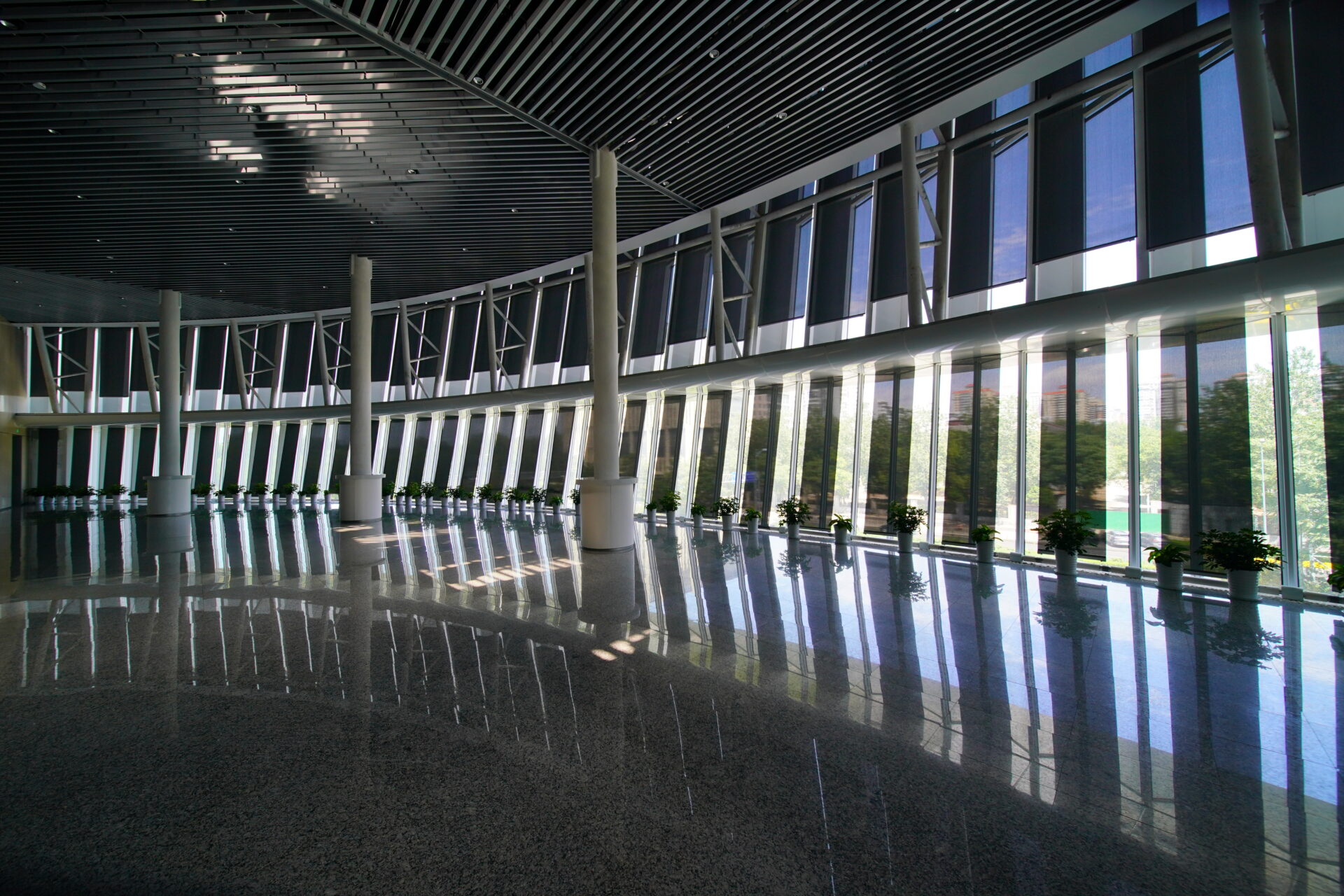 Bright interior hall with floor-to-ceiling glazing and indoor solar protection systems