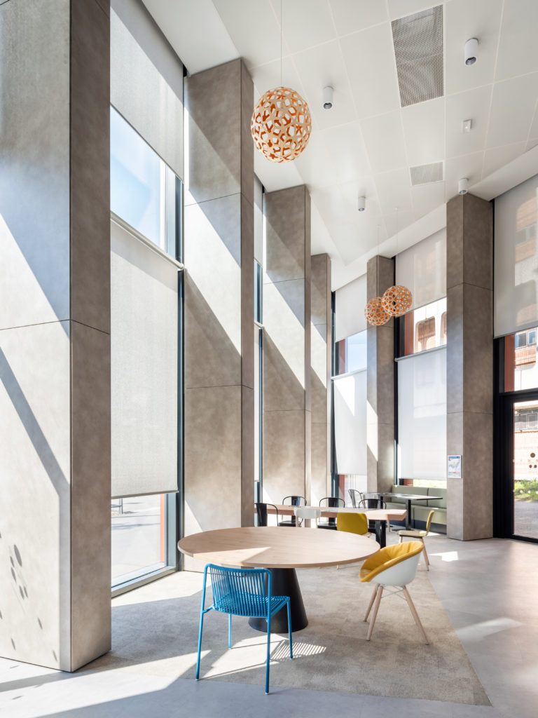 Stores enrouleurs grand format en membrane composite souple Serge Ferrari pour contrôle solaire et lumière naturelle