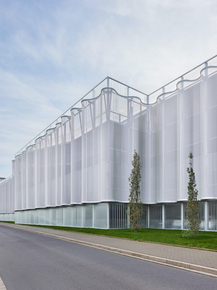 Façade ondulée en membrane textile 3D le long d’une voie urbaine