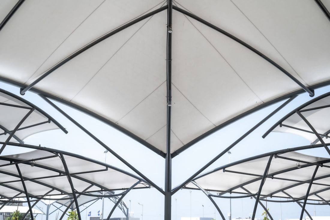 Structure d’ombrage en membrane textile pour parking, tendue sur ossature métallique.