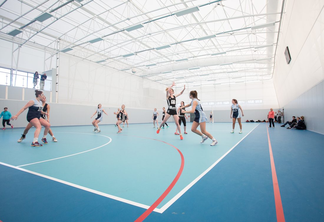 Salle de sport indoor avec toiture en membrane textile Serge Ferrari assurant lumière naturelle et confort acoustique.