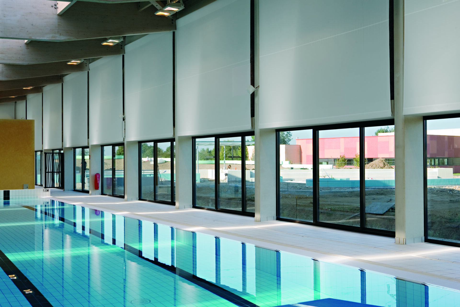Stores intérieurs en toile technique dans une piscine couverte