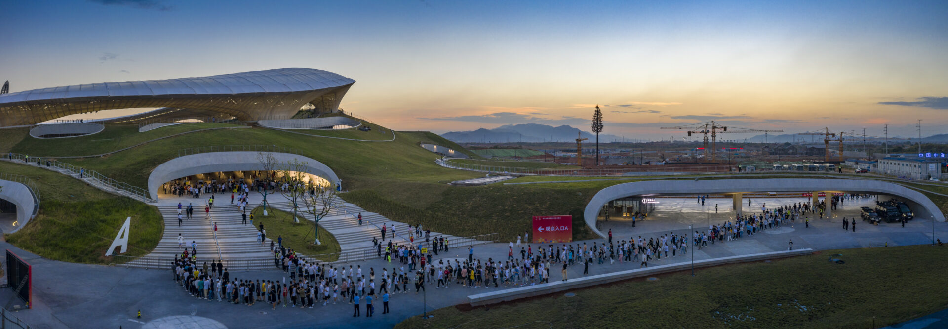 Entrée du Quzhou Stadium intégrée dans un paysage vallonné avec structure textile Serge Ferrari
