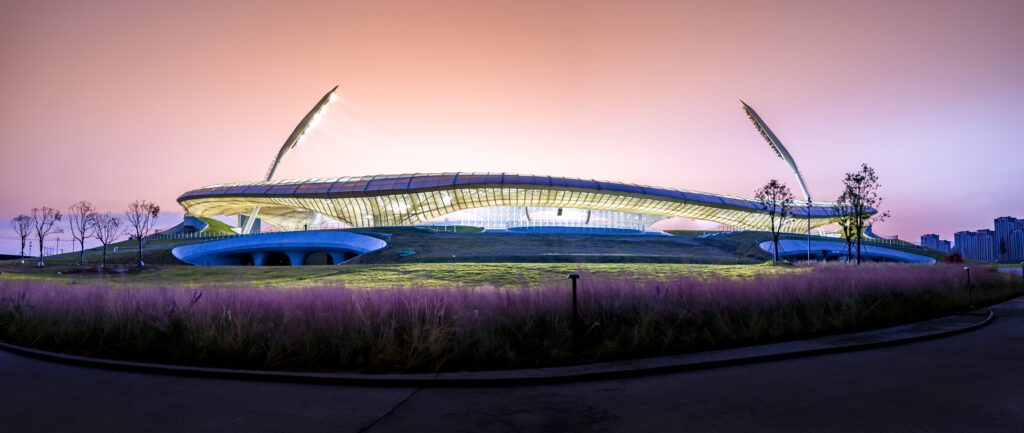 Quzhou Stadium au crépuscule avec façade lumineuse et membrane textile tendue Serge Ferrari